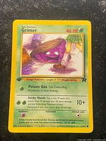 Front of 1st Edition Grimer Team Rocket card showing artwork, stats, moves and 1st edition symbols