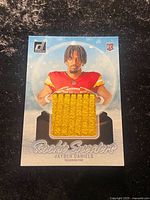 Front of 2024 Donruss Rookie Sweaters Jayden Daniels card showing embedded yellow sweater patch
