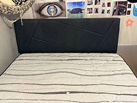 Bed with mattress showing upholstered headboard and mattress top