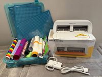 Entire lot showing Cricut Joy Xtra machine, mats, vinyl rolls, storage box, power adapter