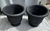 Both matching black plastic urn planters front view