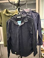 Front view of three shirts hanging