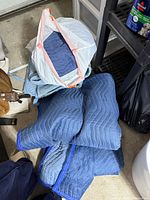 Pile of blue moving blankets, some folded
