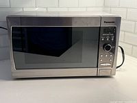 Front view showing Panasonic branding, control panel, reflective door