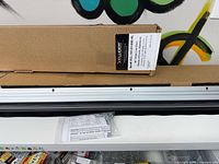 Two sealed Xcluder cartons and exposed door sweep showing aluminum retainer and black seal