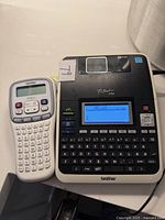 Front view of PT-2730 and handheld label maker powered on