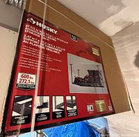 Front of sealed Husky storage rack box showing product image and specs