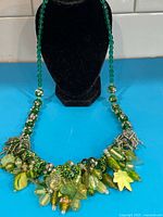 Full necklace displayed on stand showing length and clustered bead design