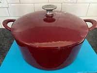 Closed Dutch oven showing red exterior and loop handles