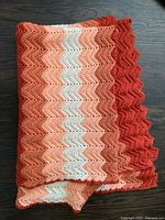Folded blanket showing overall color palette and scalloped edge