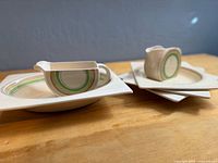 Overall view showing both creamers and three square plates