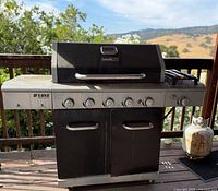 Front view of Nexgrill D'Luxe gas grill showing burners, cabinet and attached propane tank
