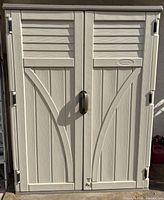 Full front view of Suncast vertical storage shed with double doors closed