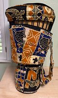 Djembe drum inside patterned carrying bag, side view