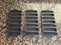 Front view of three cast iron cornstick pans showing cavity detail