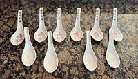 Full set of ten Chinese soup spoons laid out on counter