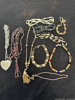 All nine necklaces laid out on black backdrop