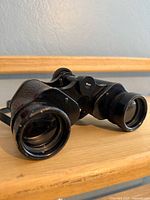 Three-quarter view showing objective lenses and leatherette panels