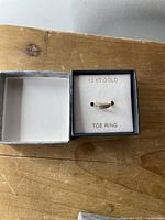 toe ring in box showing overall appearance and labeling