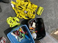 Overall view of totes with tools and yellow straps on pavement