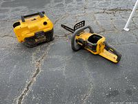 Overall view of DeWalt wet/dry vacuum and chainsaw on pavement