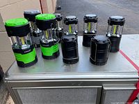 Front view of all nine lanterns, showing two green LiteAll units and seven black units