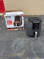 Air fryer next to original box showing brand and capacity