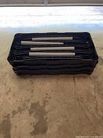 Stack of three black resin shelves with gray posts placed inside top shelf