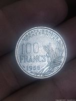 Reverse of coin showing 100 FRANCS value, date 1955, olive branches