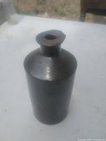 Overall view of brown stoneware ink bottle standing upright