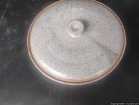 Top view of lidded stoneware dish showing speckled glaze and knob handle