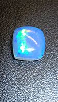 Front view of cushion cabochon opal showing play of color