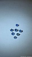 Seven round blue sapphires grouped on white background