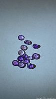 Group of small round purple amethysts on light background
