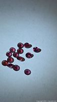 Group of loose round pink-red garnets on light background