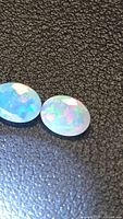 Two views of the oval faceted opal showing color play