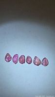 Six pink leaf-cut tourmalines lined in a row