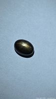 Front view of oval cabochon black star sapphire