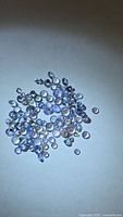 Entire parcel of round faceted tanzanite stones spread on background