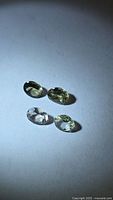 Four oval faceted gemstones under light