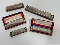Group view of 5 harmonicas and 2 open boxes