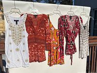 Group shot of five INC tops on hangers