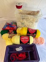 Overview of entire lot with bin, yarn skeins, lace trims, ribbon spool, organizer tray