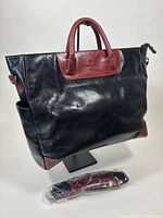 Front view of Samsonite leather briefcase tote with shoulder strap in packaging