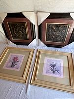 Group shot of all 4 framed pieces: two embossed panels with corner protectors, two floral prints