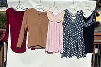 All five garments hanging on hangers for overall view