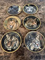 Front view of six Lenox big cat plates on table