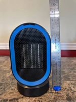 Front view showing grill, blue trim, size reference with ruler