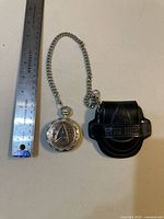 Watch, chain, pouch with ruler for scale