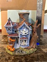 Front view of PartyLite Ghostly Tealight House with ruler showing height